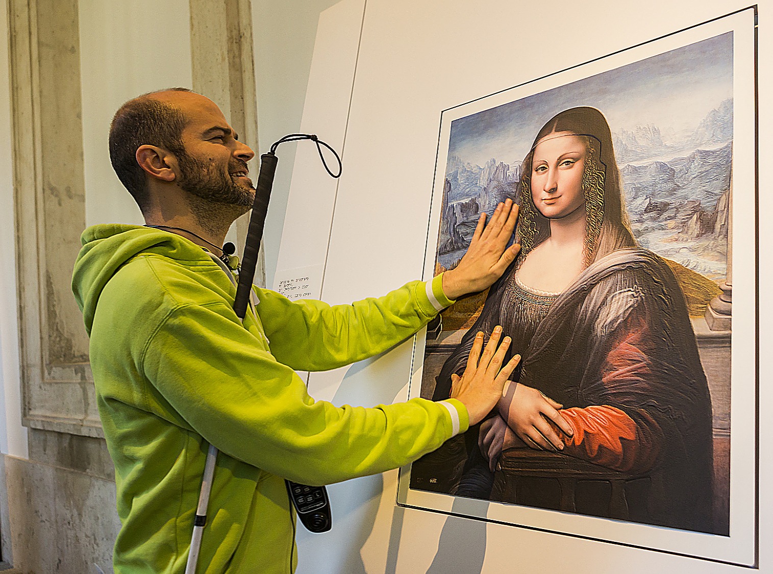 Un hombre ciego toca con sus manos un cuadro en relieve de la Mona Lisa para poder reconocer sus facciones.